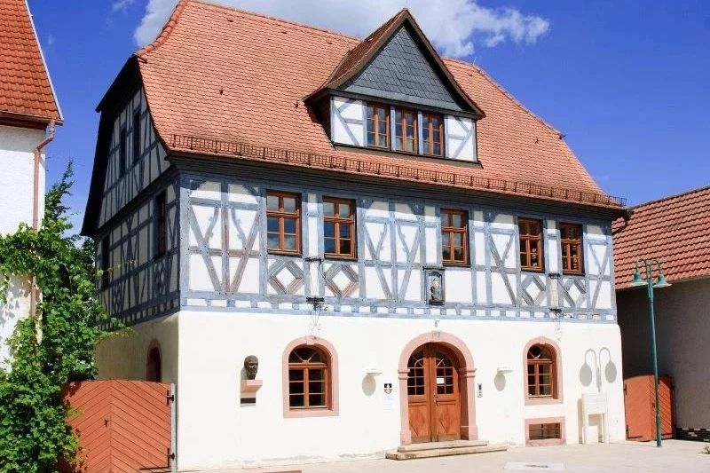Fachwerkhaus mit Satteldach und historischen Details an einem sonnigen Tag, lokalisiert in einem charmanten deutschen Dorf.